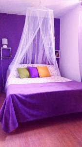 Grohote的住宿－Apartments with a parking space Rogac, Solta - 5165，卧室内的一张带天蓬的紫色床
