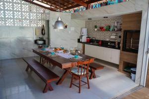 una cucina con un tavolo di legno e un bancone di Casa na Praia dos Carneiros/PE. Cond. Village IV. a Tamandaré