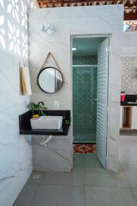 a bathroom with a sink and a mirror at Casa na Praia dos Carneiros/PE. Cond. Village IV. in Tamandaré