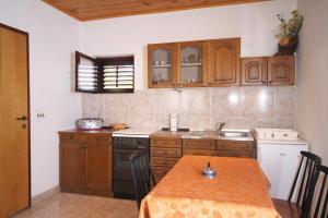uma cozinha com uma mesa, um fogão e um lavatório em Apartments by the sea Stomorska, Solta - 5164 em Stomorska
