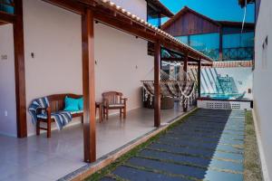 eine Terrasse mit Stühlen und einer Hängematte auf einem Haus in der Unterkunft Casa na Praia dos Carneiros/PE. Cond. Village IV. in Tamandaré