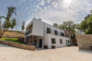 een wit huis met een stenen muur bij Be Alva in Oliveira do Hospital