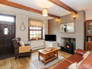 a living room with a couch and a fireplace at Shenton Cottage in Buxton