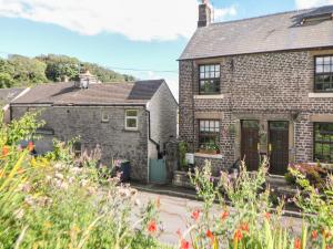 an old brick house with a garden in front of it at Shenton Cottage in Buxton