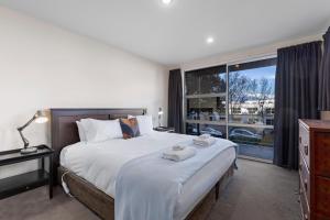 1 dormitorio con cama grande y ventana grande en Mountain View en Queenstown