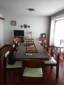 comedor con mesa con sillas y TV en Casa 70 en La Plata