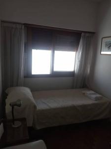 1 dormitorio con cama y ventana en Casa 70 en La Plata