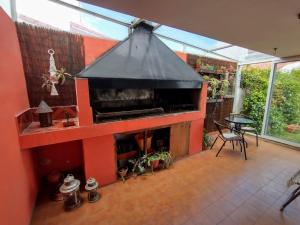 an outdoor kitchen with a fireplace in a house at Casa Carlos Paz in Villa Carlos Paz