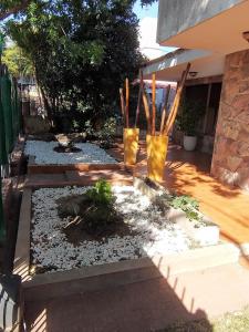 un jardín con dos jarrones amarillos en un patio en Casa Carlos Paz en Villa Carlos Paz