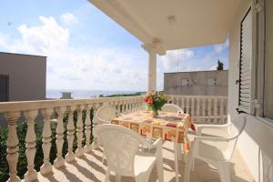 a table and chairs on a balcony with a view of the ocean at Apartments with a parking space Rukavac, Vis - 8838 in Vis