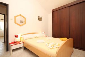 a bedroom with a bed and a wooden cabinet at Apartments with a parking space Rukavac, Vis - 8838 in Vis