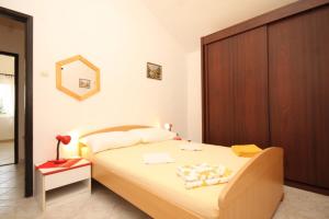 sypialnia z łóżkiem i drewnianą szafką w obiekcie Apartments with a parking space Rukavac, Vis - 8838 w mieście Vis