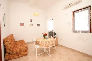 a dining room with a table and chairs and a window at Apartment Rukavac 8837f in Vis