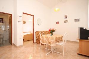 a living room with a table with a vase of flowers on it at Apartment Rukavac 8837f in Vis