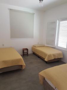 a room with two beds and a window at Casa da Barra Delfinopolis in Delfinópolis