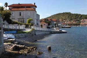 a building on the shore of a body of water at Apartments by the sea Vis - 8932 in Vis