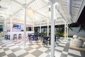 a patio with tables and chairs and a bar at White Horse Resort in Nusa Lembongan