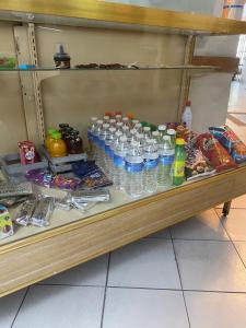 a shelf filled with bottles of water and food at Hotel Angel in León