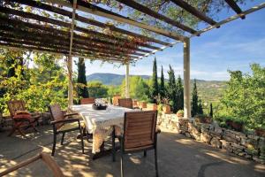 a table and chairs under a pergola on a patio at Family friendly house with a swimming pool Talez, Vis - 8850 in Vis