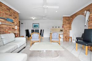 sala de estar con sofá blanco y sillas en Byron Bay Accom Unit 6 70 Lawson Street - Atlantis, en Byron Bay