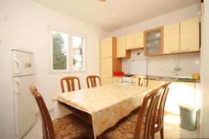 a kitchen with a table with chairs and a refrigerator at Apartments with a parking space Rukavac, Vis - 8849 in Vis