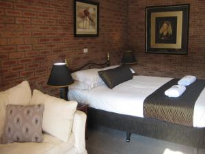 1 dormitorio con 2 camas y sofá en Bulahdelah Motor Lodge, en Bulahdelah