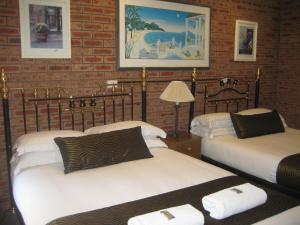 a room with two beds and a brick wall at Bulahdelah Motor Lodge in Bulahdelah