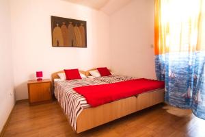 a bedroom with a bed with a red blanket at Apartments by the sea Stomorska, Solta - 8650 in Stomorska