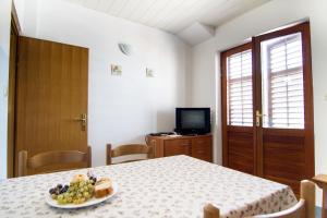 a room with a table with a plate of fruit on it at Apartments by the sea Stomorska, Solta - 8650 in Stomorska