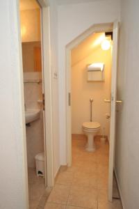 a bathroom with a toilet and a sink and a tub at Apartments and rooms by the sea Komiza, Vis - 8841 in Komiža