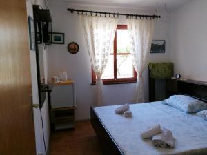 a bedroom with a bed and a window with towels on it at Apartments and rooms by the sea Komiza, Vis - 8841 in Komiža