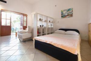a bedroom with a bed and a chair in it at Apartments and rooms with parking space Komiza, Vis - 8844 in Komiža