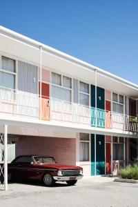 un coche rojo estacionado frente a un edificio en Astor Hotel Motel en Albury