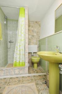a bathroom with a yellow shower curtain and a toilet at Apartments with a parking space Rukavac, Vis - 8859 in Vis