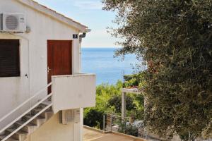 a house with a door and a view of the ocean at Apartments with a parking space Rukavac, Vis - 8859 in Vis