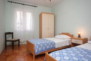 a bedroom with two beds and a chair at Apartments by the sea Vis - 8534 in Vis