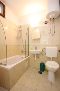 a bathroom with a tub and a toilet and a sink at Apartments by the sea Vis - 8534 in Vis