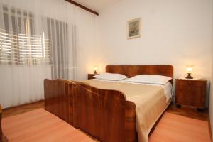 a bedroom with a large wooden bed with two lamps at Apartments with a parking space Vis - 8861 in Vis