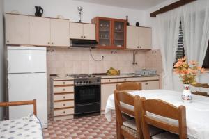 a kitchen with a table and a refrigerator and a stove at Apartments with a parking space Vis - 8861 in Vis