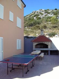 a ping pong table in front of a building at Apartments with a parking space Seget Vranjica, Trogir - 8507 in Seget Vranjica