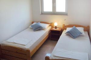 two twin beds in a room with a window at Apartments with a parking space Seget Vranjica, Trogir - 8507 in Seget Vranjica