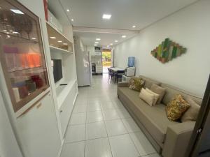 a living room with a couch and a tv at Nannai Residence in Porto De Galinhas