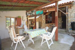 a table and chairs on a patio with a kitchen at Apartments with a parking space Rukavac, Vis - 8864 in Rukavac