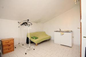 a room with a bed and a green ottoman at Apartment Rukavac 8864b in Rukavac