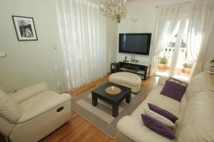 a living room with white furniture and a flat screen tv at Apartments by the sea Split - 8671 in Split