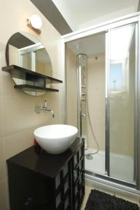a bathroom with a sink and a shower with a mirror at Apartments by the sea Split - 8671 in Split