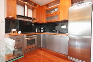 a kitchen with stainless steel appliances and wooden cabinets at Apartments with a parking space Split - 8681 in Split