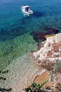 um barco na água ao lado de uma costa rochosa em Apartments with WiFi Trsteno, Dubrovnik - 8738 em Trsteno