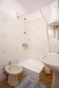 a bathroom with a tub and a sink and a toilet at Apartments with WiFi Trsteno, Dubrovnik - 8738 in Trsteno