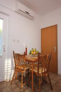 a wooden table with chairs and a bowl of fruit on it at Apartments with WiFi Trsteno, Dubrovnik - 8738 in Trsteno